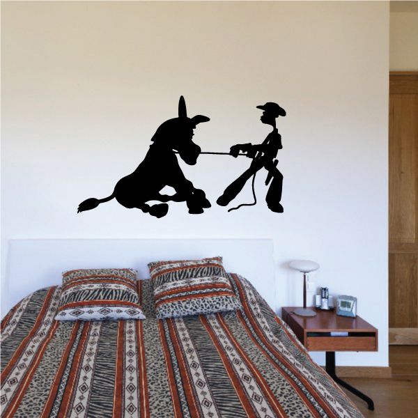 Black vinyl wall decal of a donkey and rider holding a tool