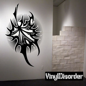 Black tribal tattoo wall decal with bold swirls and face-like design