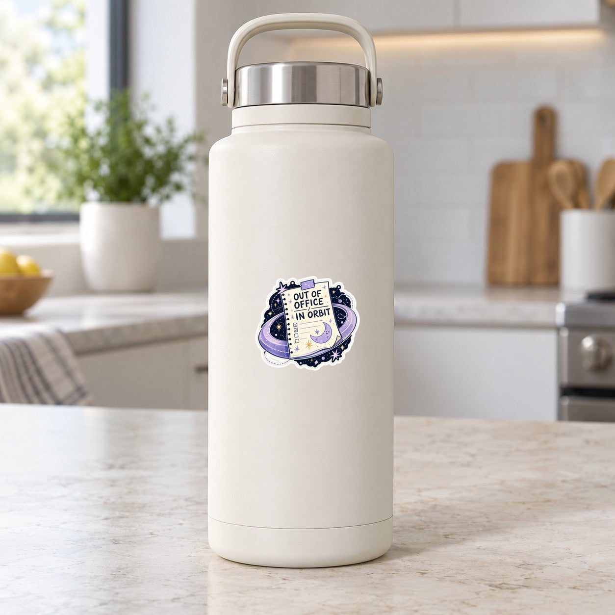 Small space-themed sticker on white tumbler showing 'Out of Office in Orbit' text