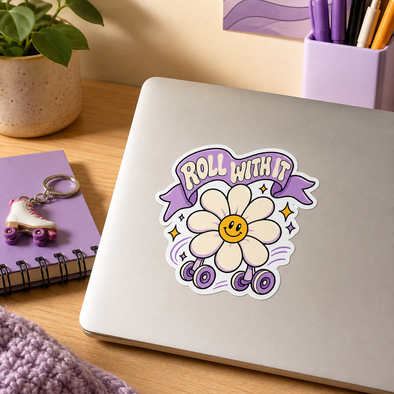 Roll With It daisy vinyl sticker on a gray notebook cover