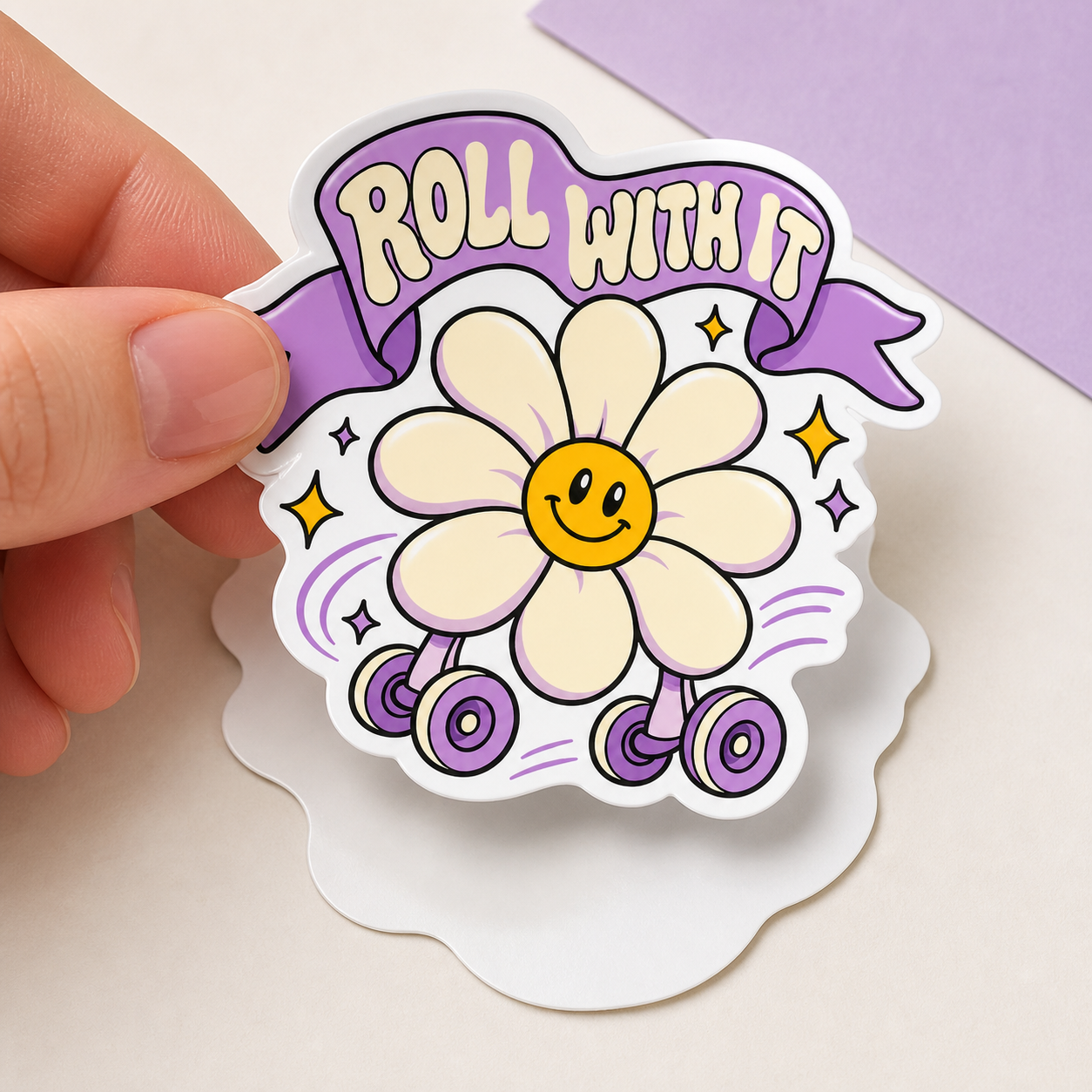 Close-up of “Roll With It” daisy vinyl sticker held in hand