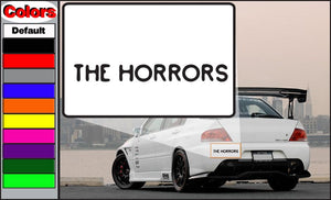 Car window decal with bold black text 'THE HORRORS' on white rectangle