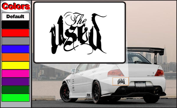 Used decal sticker with bold black stylized lettering on a white backing