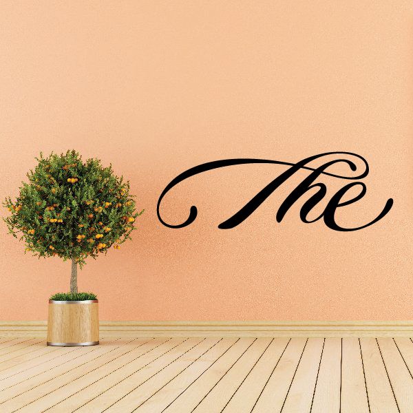 Cursive wall decal reading 'The' in black with decorative swirls