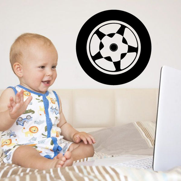 Circular tire rim wall decal with black outer ring and white checkered spokes