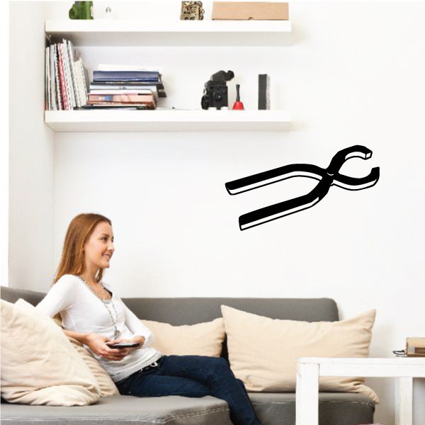 Black tongs wall decal with two hinged tong arms and circular ring handle.