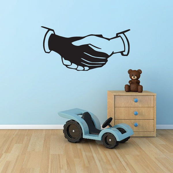 Unity hands decal, black handshake silhouette with white outline on a wall
