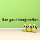 Wall decal with “Use your imagination” lettering and three yellow cartoon figures with goggles.