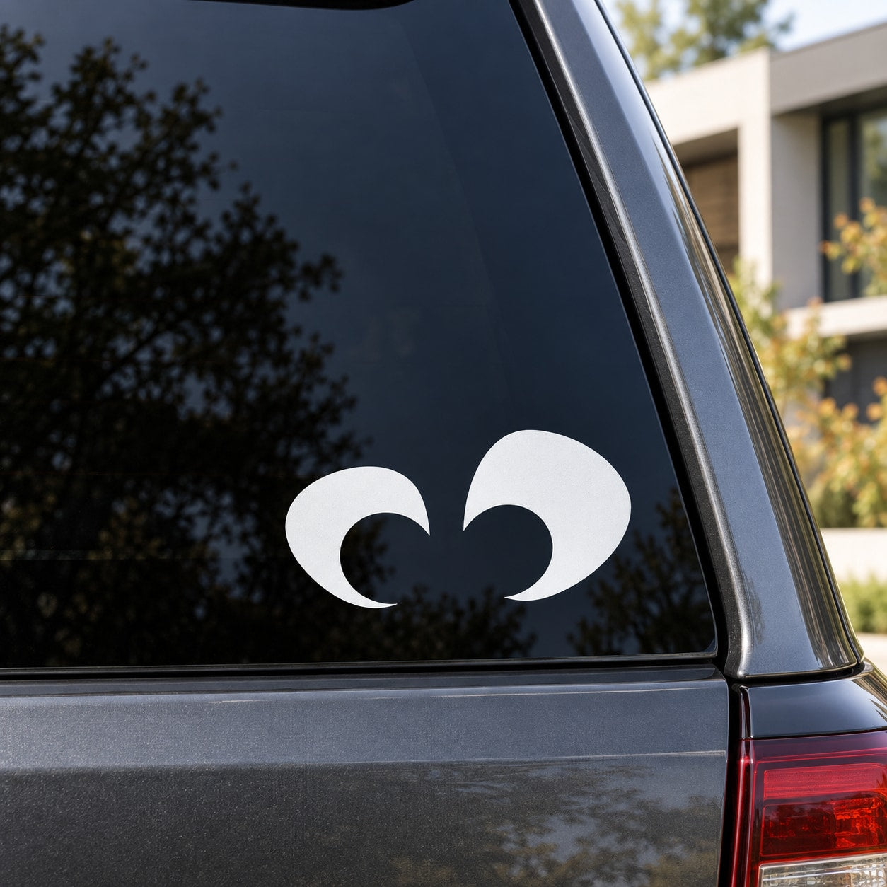 White crossed-eyes face decal on car rear window