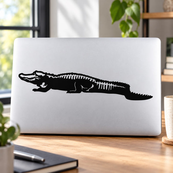 Resting alligator decal, black silhouette on light laptop lid
