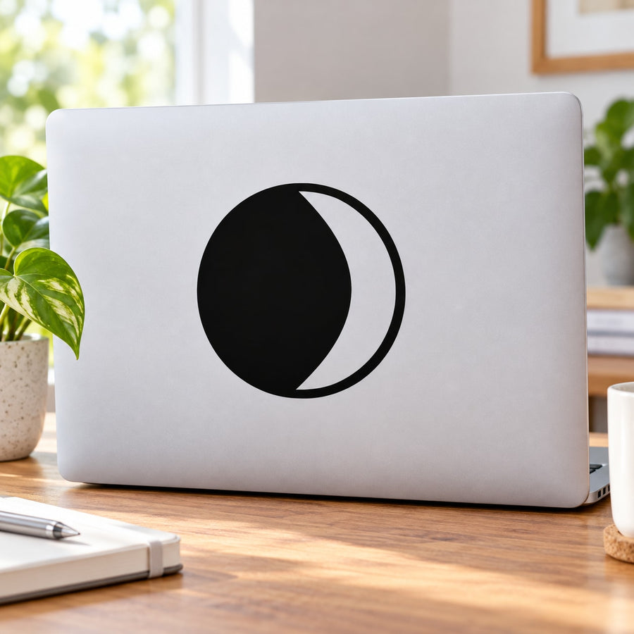 Black crescent moon astrology symbol decal on light-colored laptop lid