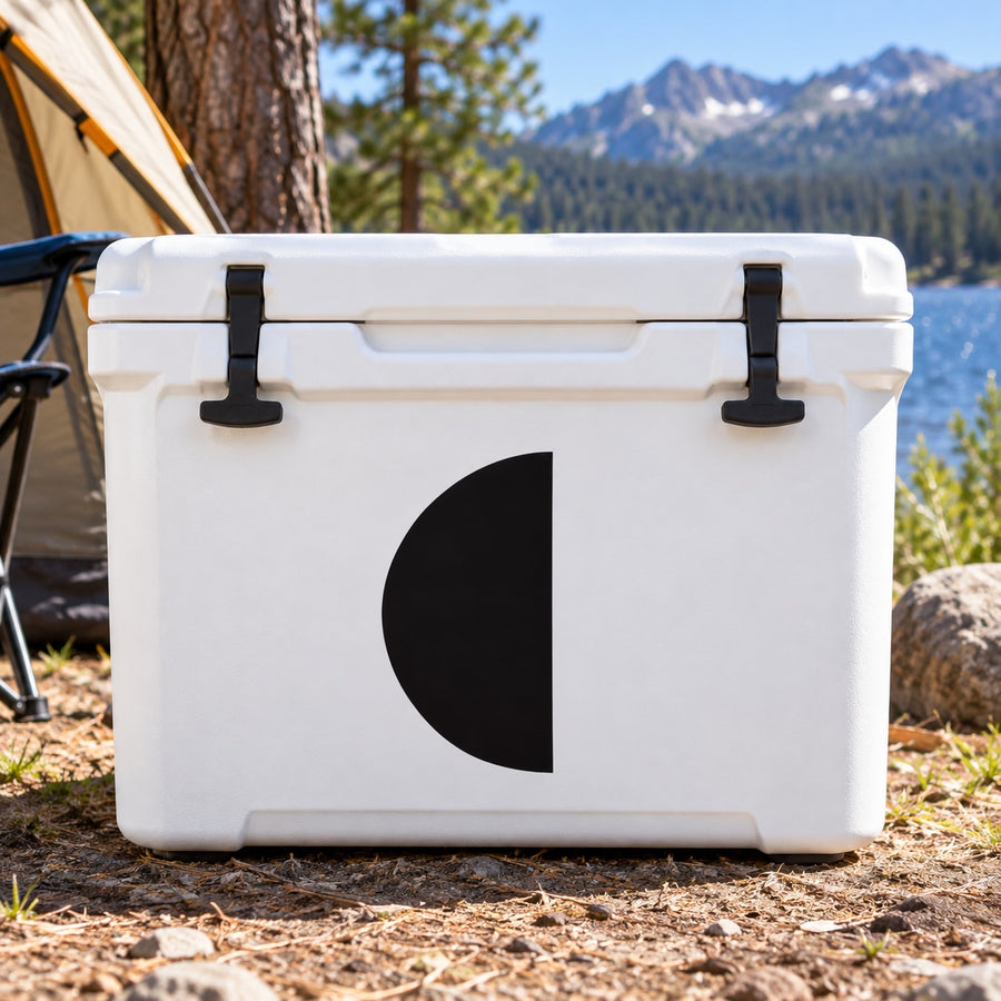 White hard-sided cooler with black quarter-moon emblem and latch handles