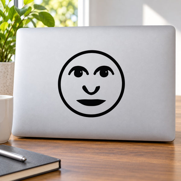 Moon man face decal with smiling black moon outline and facial features on a light surface