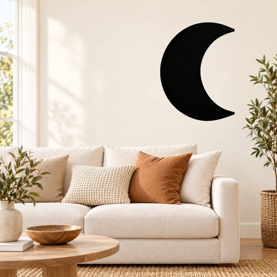 Waxing gibbous moon wall decal, black crescent on plain wall above sofa