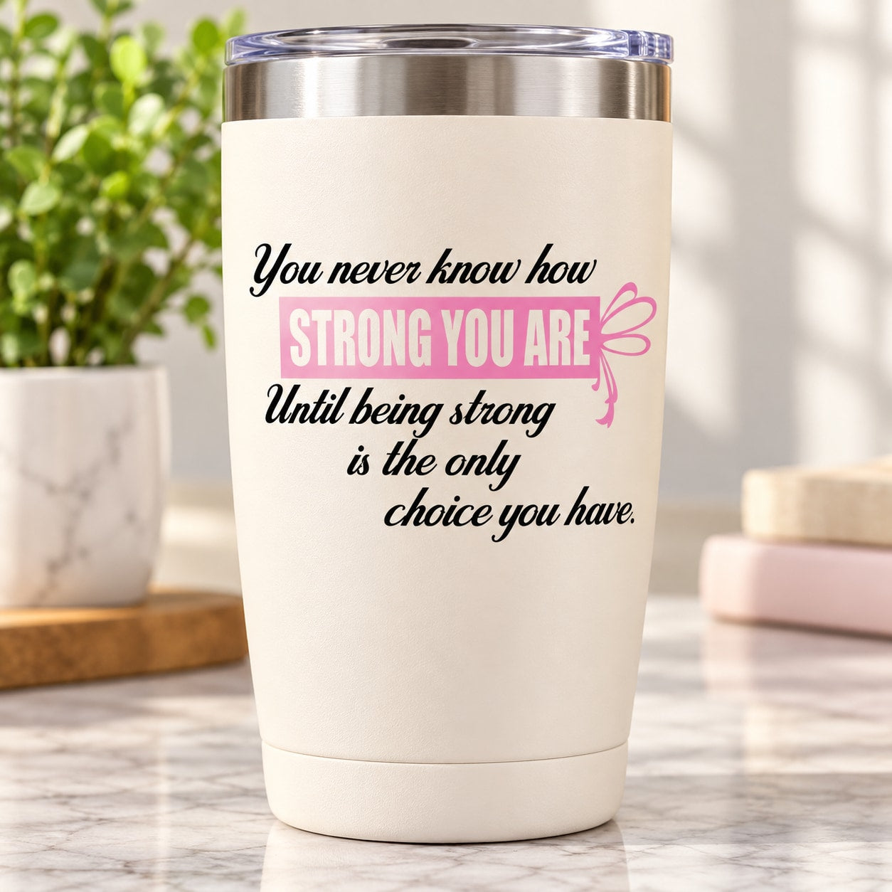 White quote-printed tumbler with motivational text and pink ribbon graphic