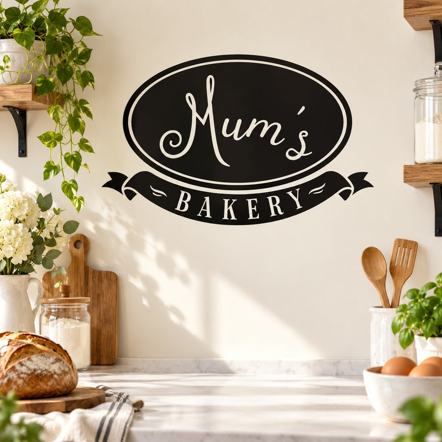 Black oval Mum's Bakery wall decal with white script and ribbon banner