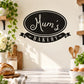 Black oval Mum's Bakery wall decal with white script and ribbon banner