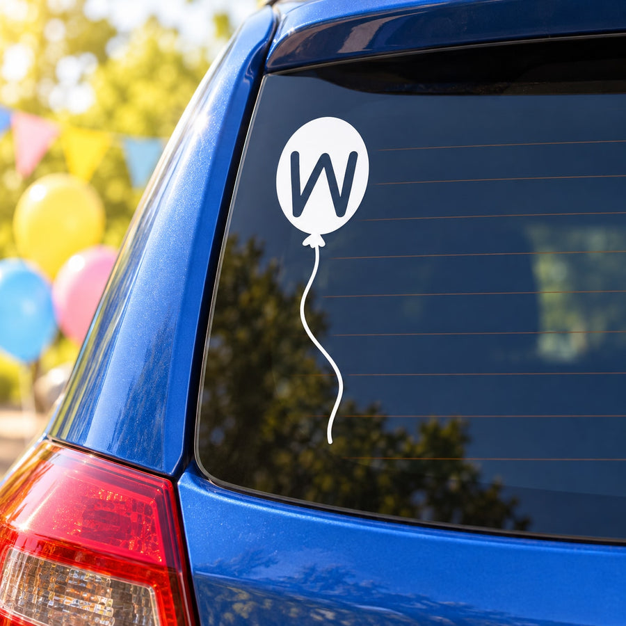 Letter W balloon decal on car window: white circle with black W and balloon string.