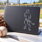 Baseball batter outline sticker on dark rectangular backing, white line art batter