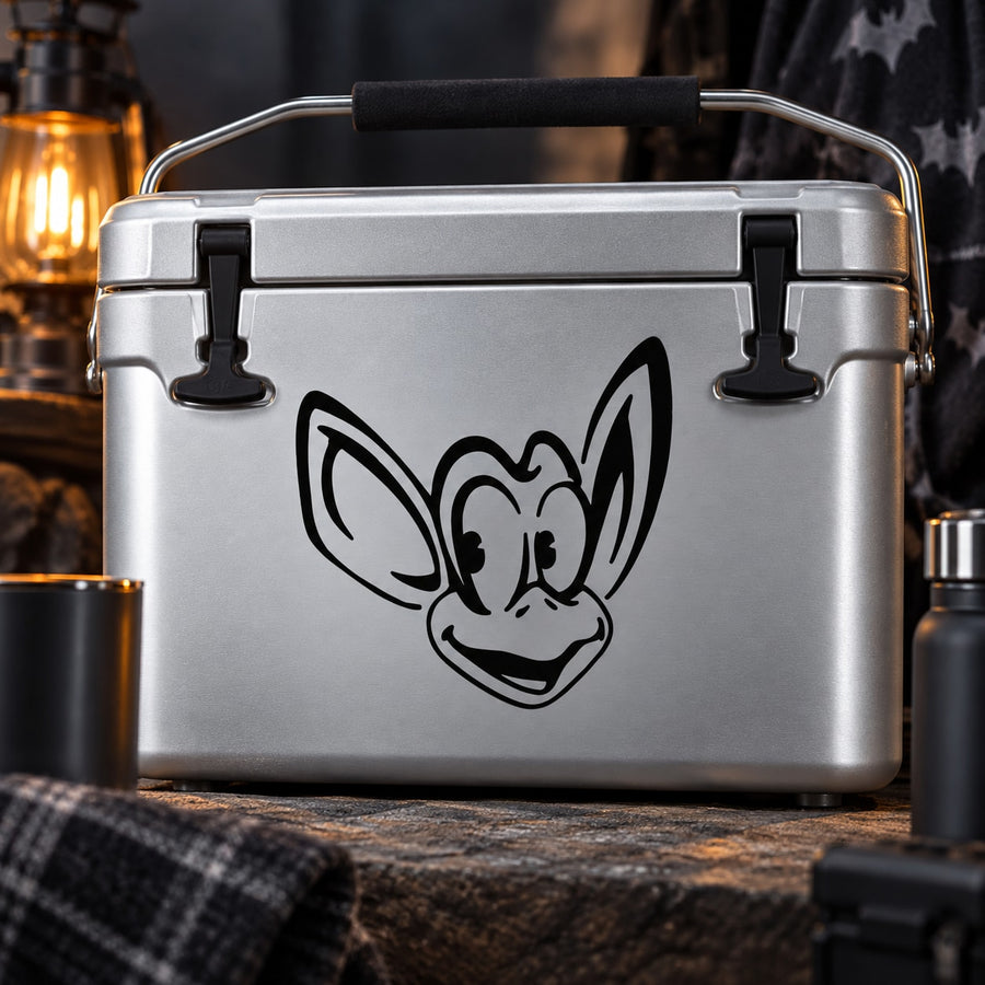 Cartoon bat decal with black bat face and wings on a gray metal surface