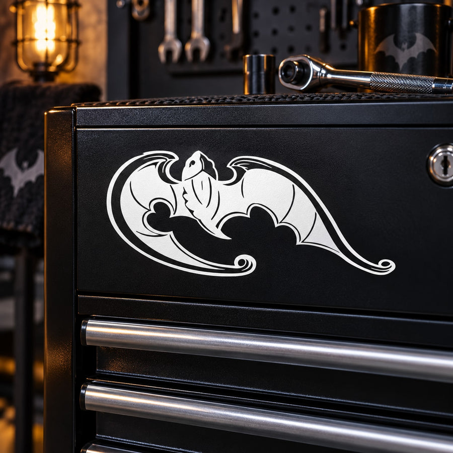 Decorative white bat-like motif decal on a black metal cabinet front
