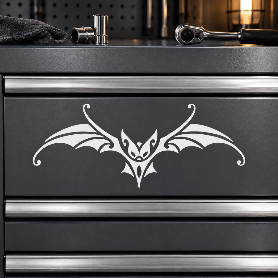 Victorian bat decal with ornate white bat-wing design on dark metal surface