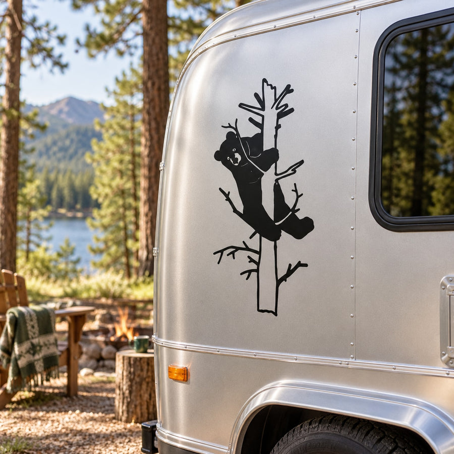 Black bear silhouette peeking from a tree branch decal