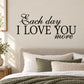 Wall decal with black text: 'Each day I LOVE YOU more' and heart flourish