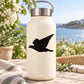 Seagull in-flight decal on a cream water bottle, black bird silhouette