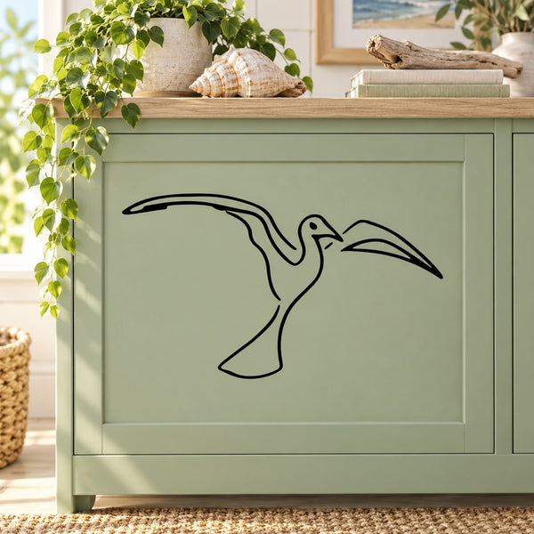 Black shore bird wall decal with wings spread, outlined on a light green cabinet