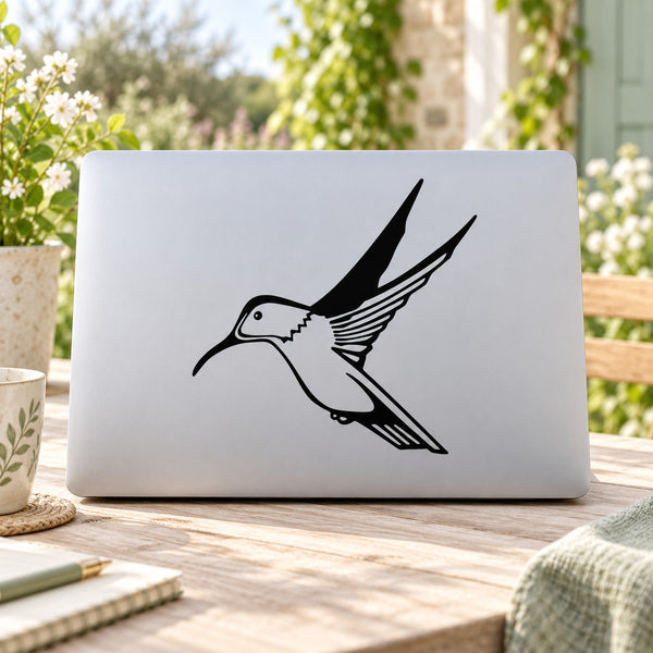 Black hummingbird decal with outstretched wings on a light rectangular surface