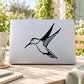 Black hummingbird decal with outstretched wings on a light rectangular surface