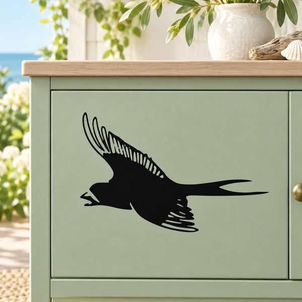 Black chirping swallow wall decal on a light green cabinet drawer