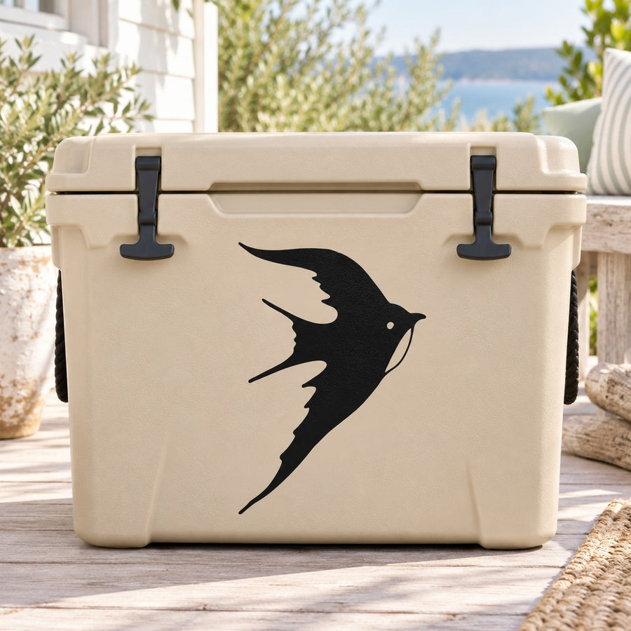 Black flying swallow decal on light-colored cooler with latch hardware visible
