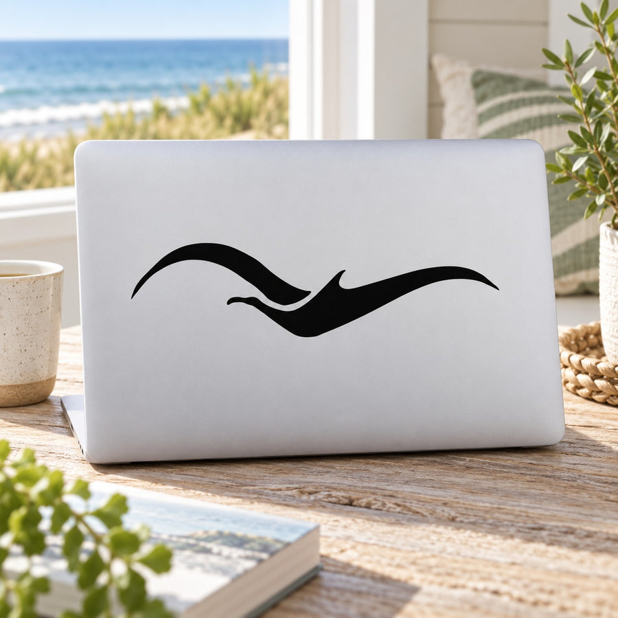 Flying bird decal in black, wave-like wings on a laptop