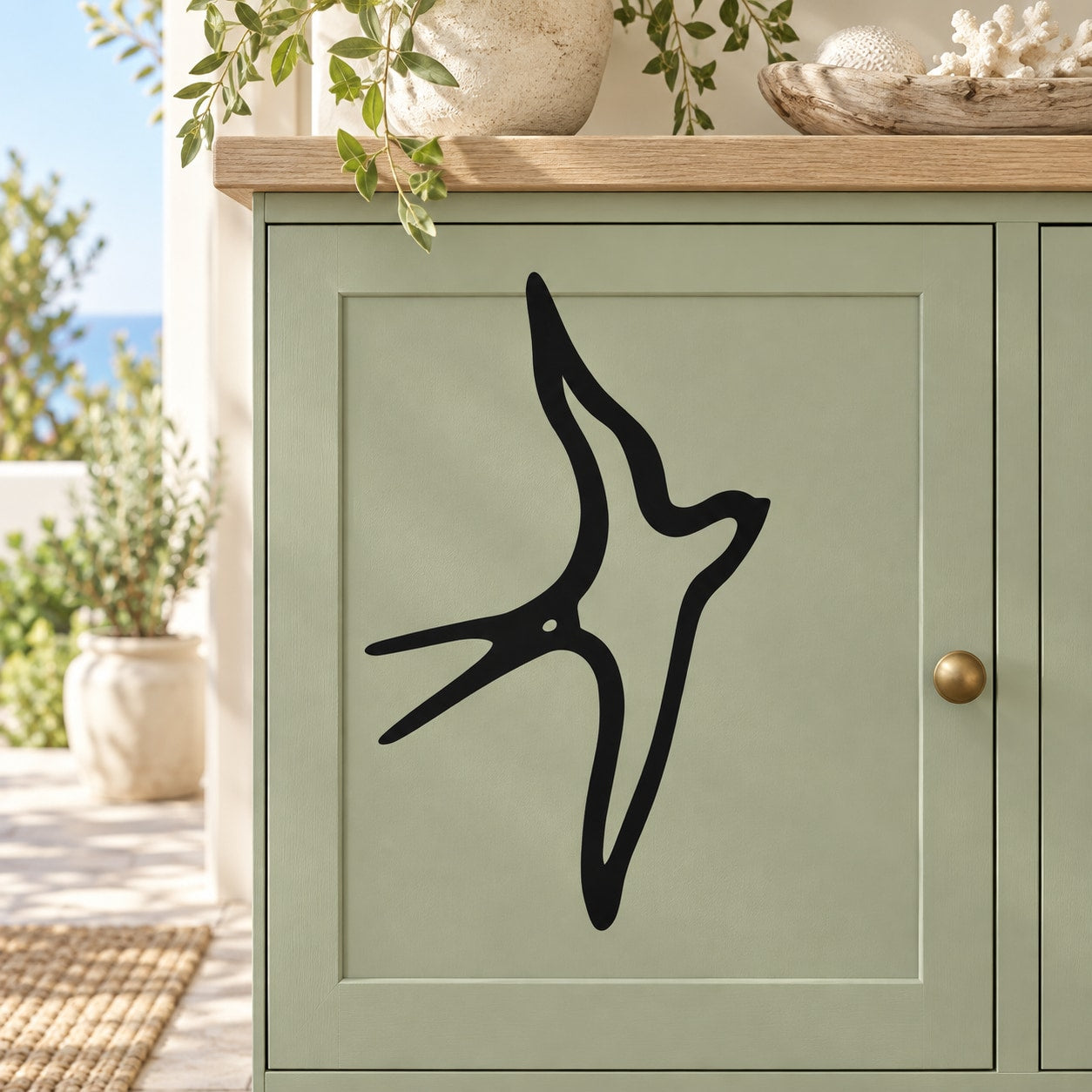 Swallow outline decal with a black bird silhouette on a pale door panel