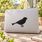 Perched swallow bird decal with black silhouette on a light laptop lid