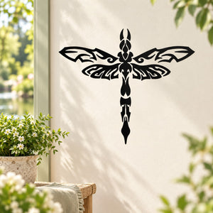 Black ornate dragonfly decal with symmetrical wings and filigree center on beige surface