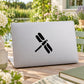 Simplified dragonfly decal sticker on gray laptop lid, black outlined design