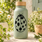 Ladybug decal with black outline and dot spots on a bottle