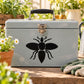 Black spread-bee vinyl decal on a light gray metal surface