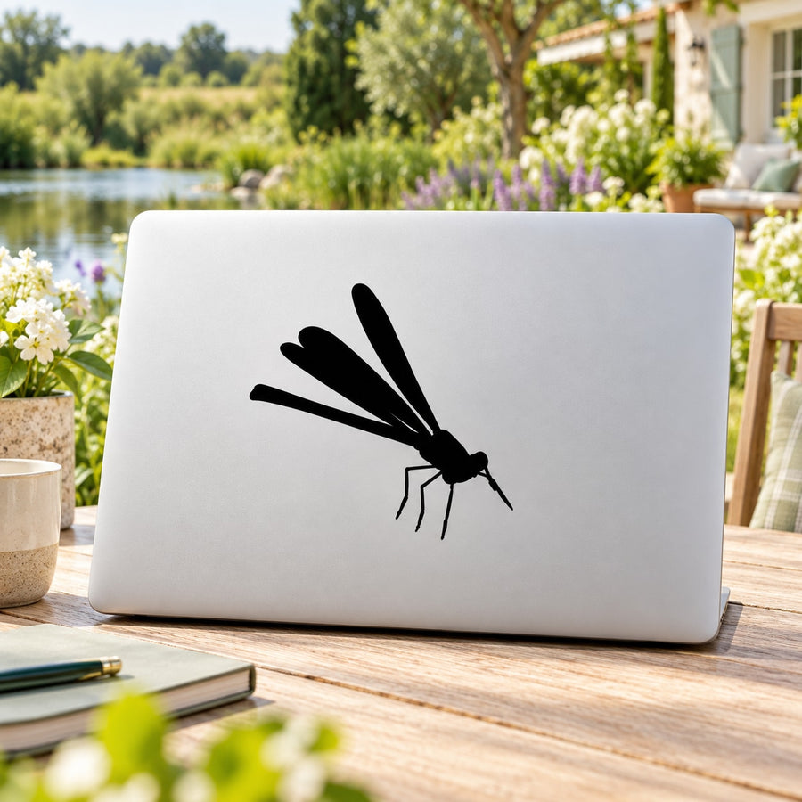 Dragonfly decal sticker with black insect design on white laptop lid