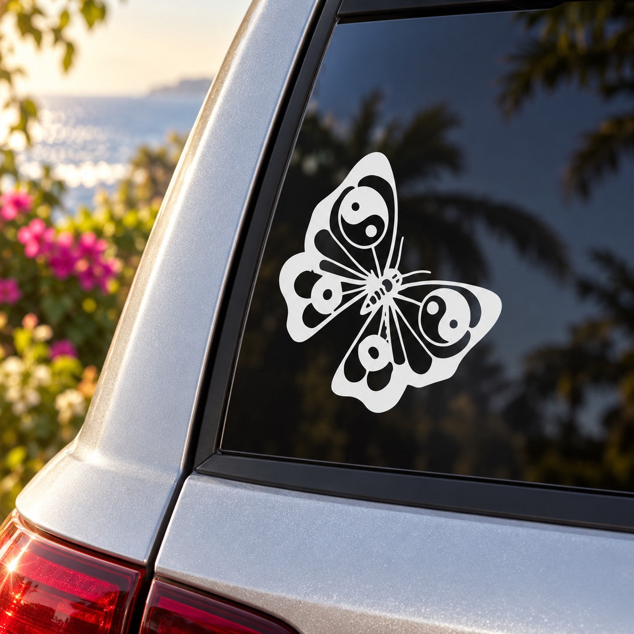 Butterfly decal with yin-yang wing pattern on car window