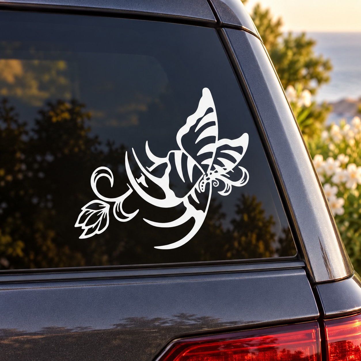 White butterfly vinyl car decal on car window with swirling floral accents