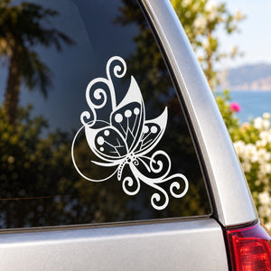 White butterfly vinyl decal with ornate swirls on dark car surface