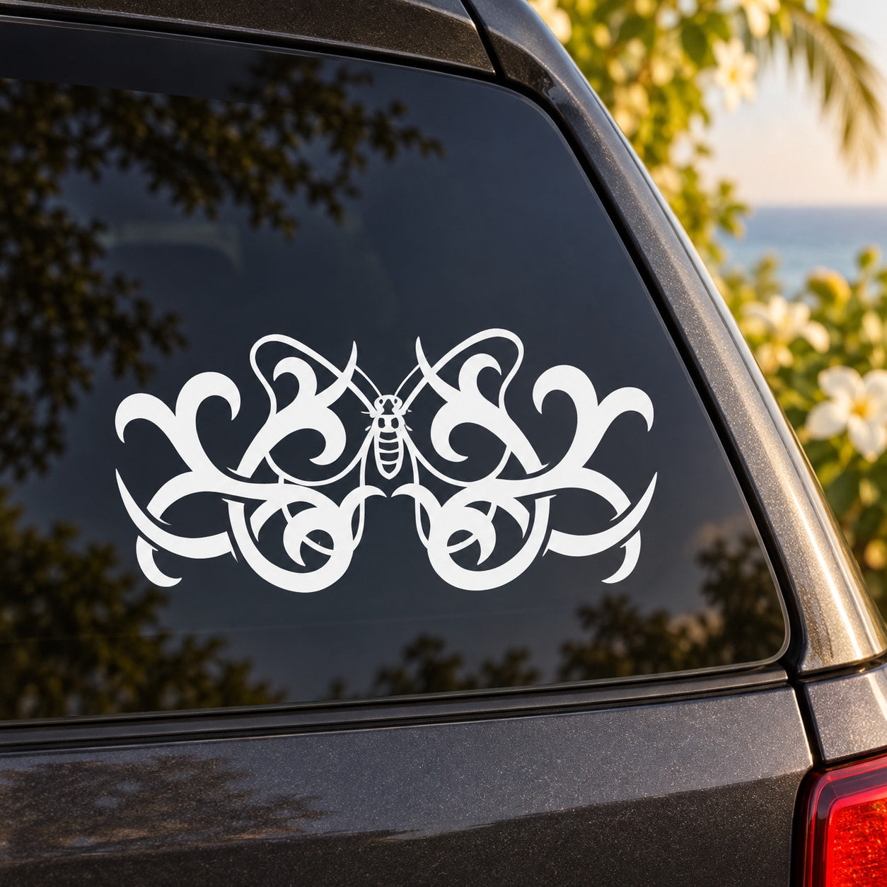 White ornate butterfly vinyl decal with decorative swirls on a car window