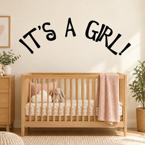 Baby shower wall decal reading “It’s a Girl!” in black lettering