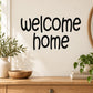 Welcome home wall decal with bold black hand-lettered script