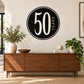 Black circular decal with large white “50” and vertical “YEARS” lettering.