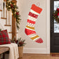 Red and white Christmas stocking with patterned stripes and gold top